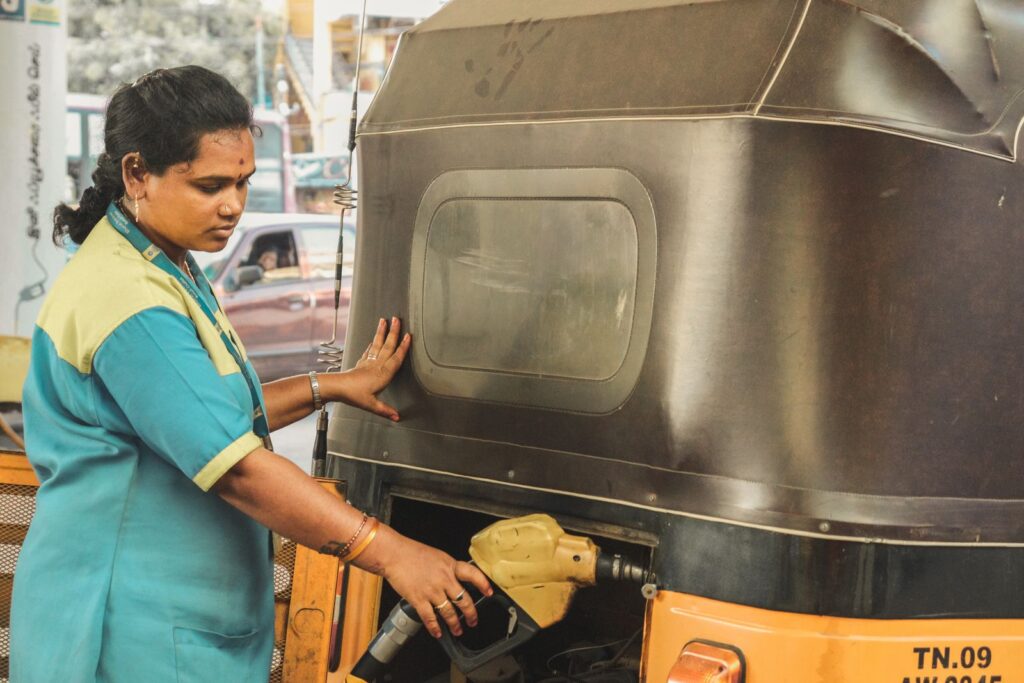 Fuel station attendant refuelling a vehicle with compressed gas